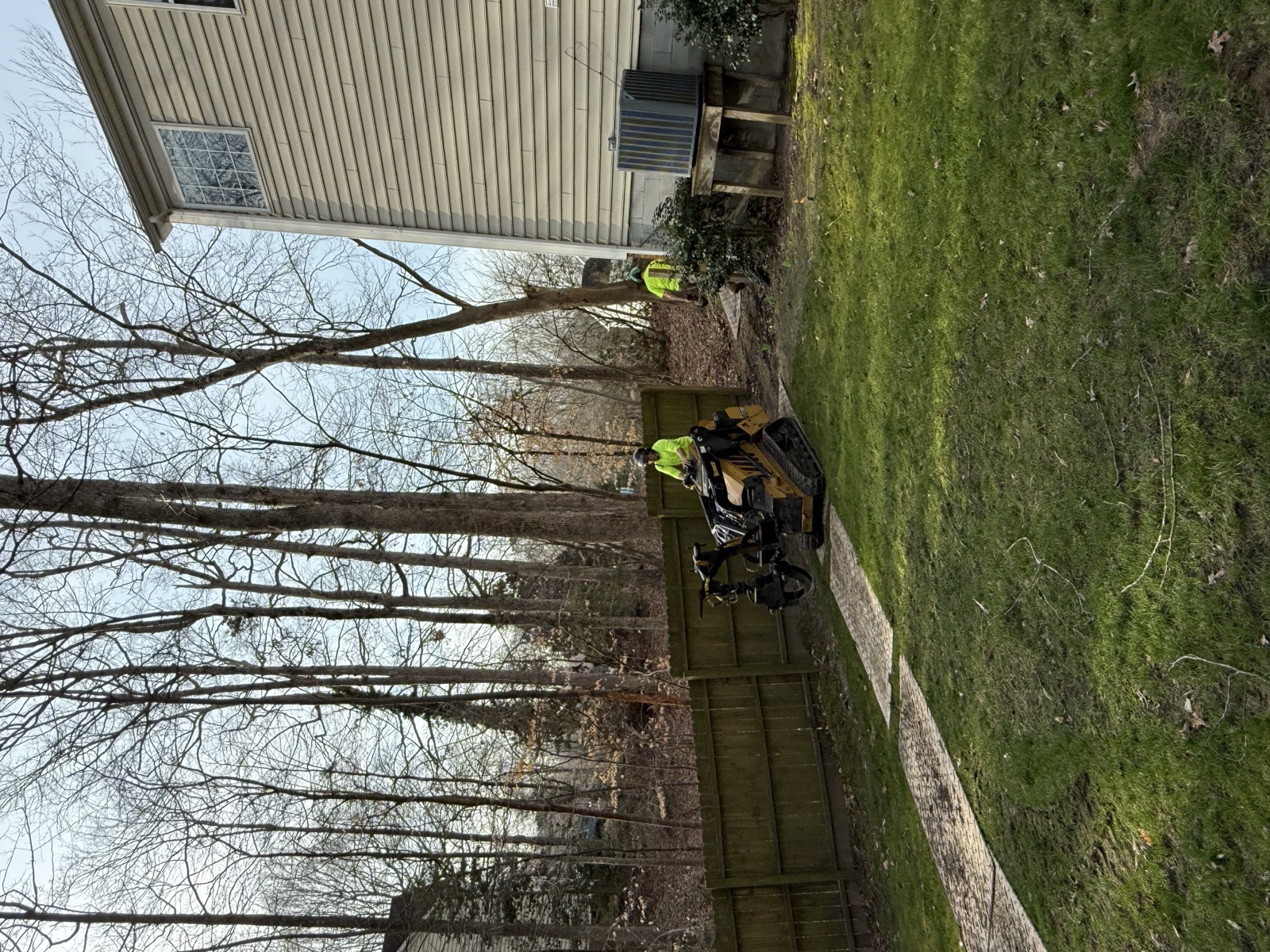 Johnny Timbers crew using ground protection mats to protect lawn while operating equipment through fence Williamsburg VA